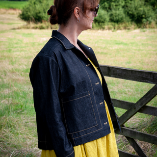 Lady Wearing The Gertrude Jacket Sewing Pattern In Indigo Stretch Denim Fabric Over The Lavinia Dress In Laundered Linen Chartreuse