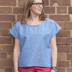 Female wearing the Peaseblossom Top Sewing Pattern in blue chambray fabric