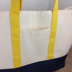 Close up of Arden Shopper Bag in navy and cream with contrasting yellow fabric, showing front pocket detail.